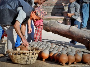Nepalese Man , collecting his sun dried Clay Pots before sunset . Been doing this every day for years . These claypots are used to keep yogurts, a staple food of Nepalese.